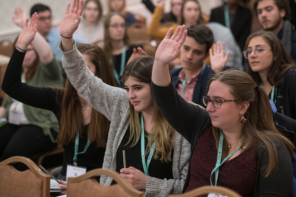 Several undergraduate students raise their hands at the AHA 2018 Annual Meeting.